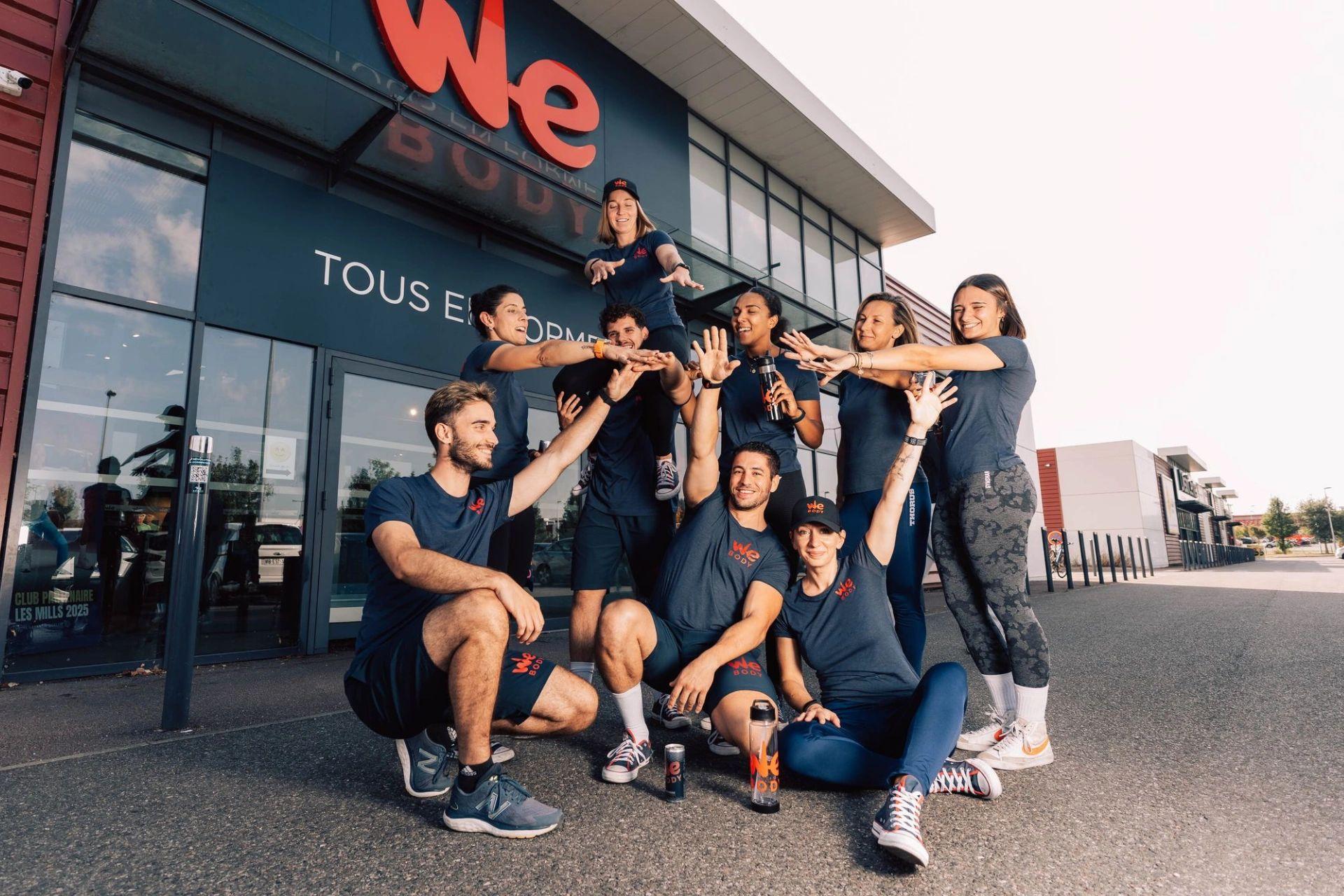 L'équipe de Webody pose en tenue sportive devant leur magasin lors d'une séance photo d'équipe