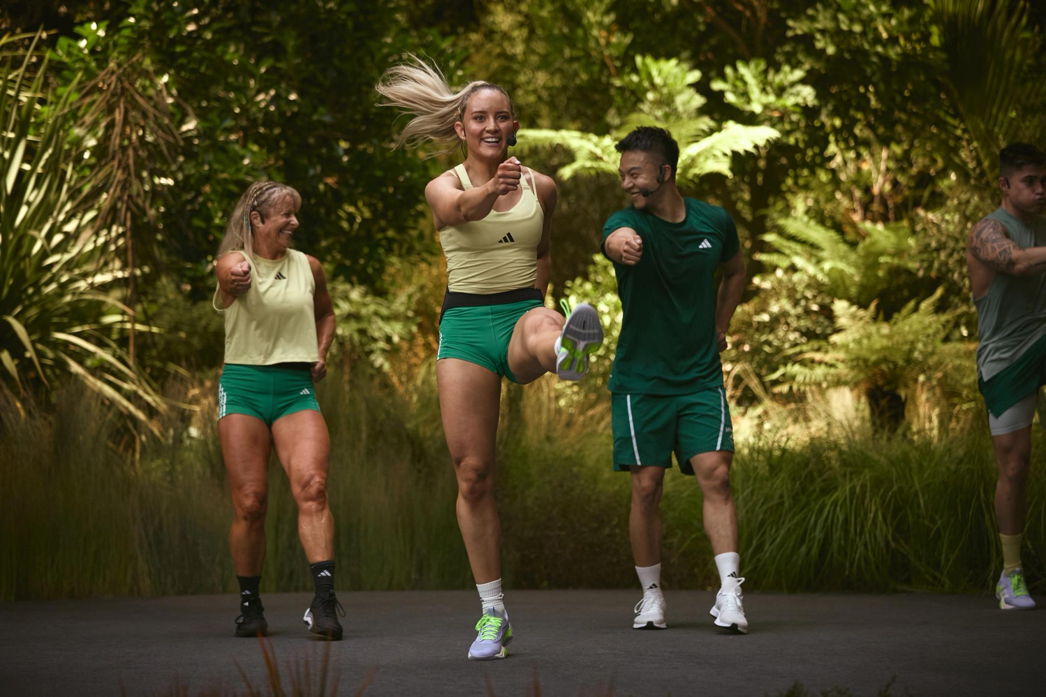 Groupe de coureurs en tenue Adidas s'entraînant sur un sentier verdoyant à Webody Saint-Orens