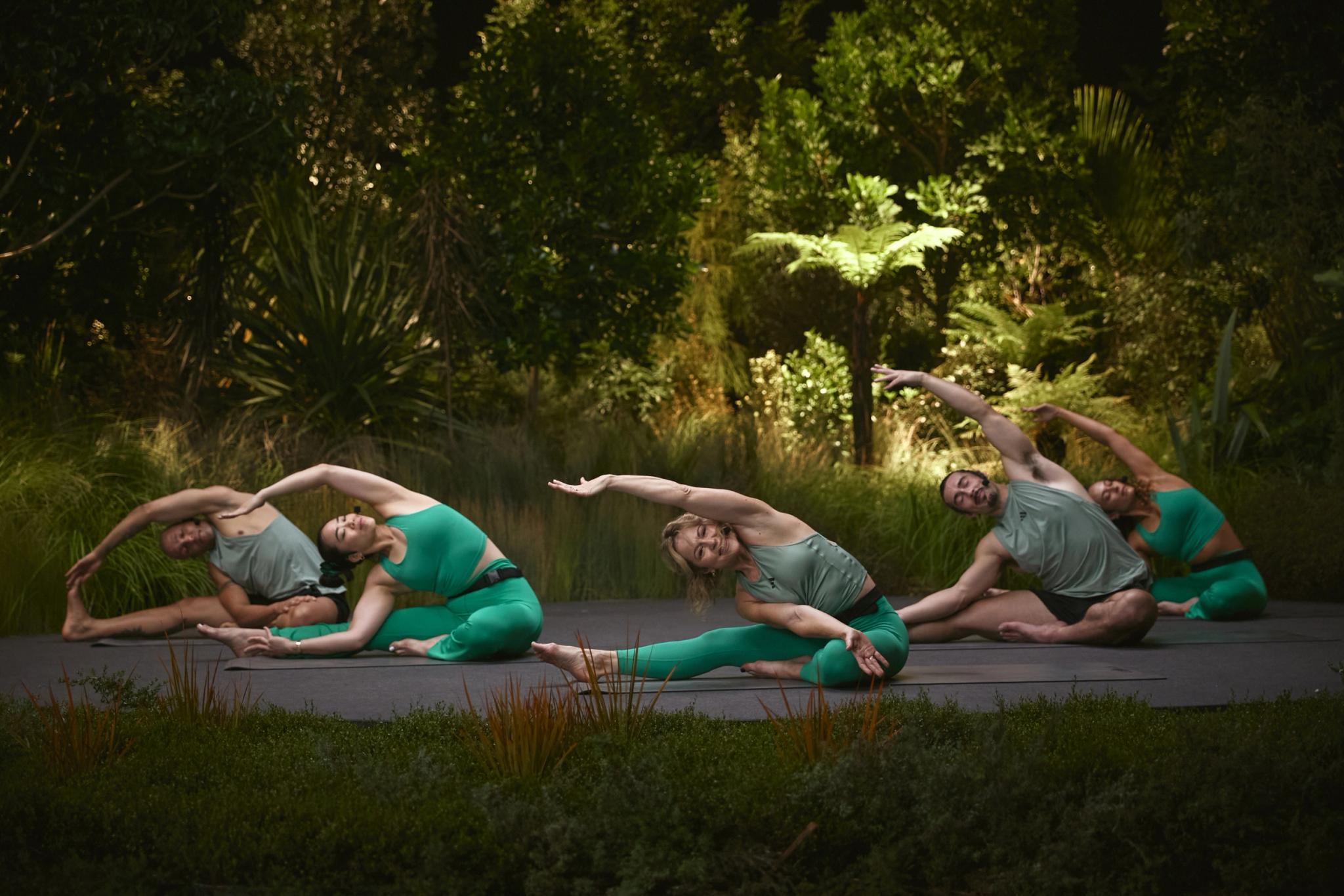 Cours de yoga en groupe à Webody Saint-Orens avec des femmes pratiquant des poses de flexion sur un pont en bois