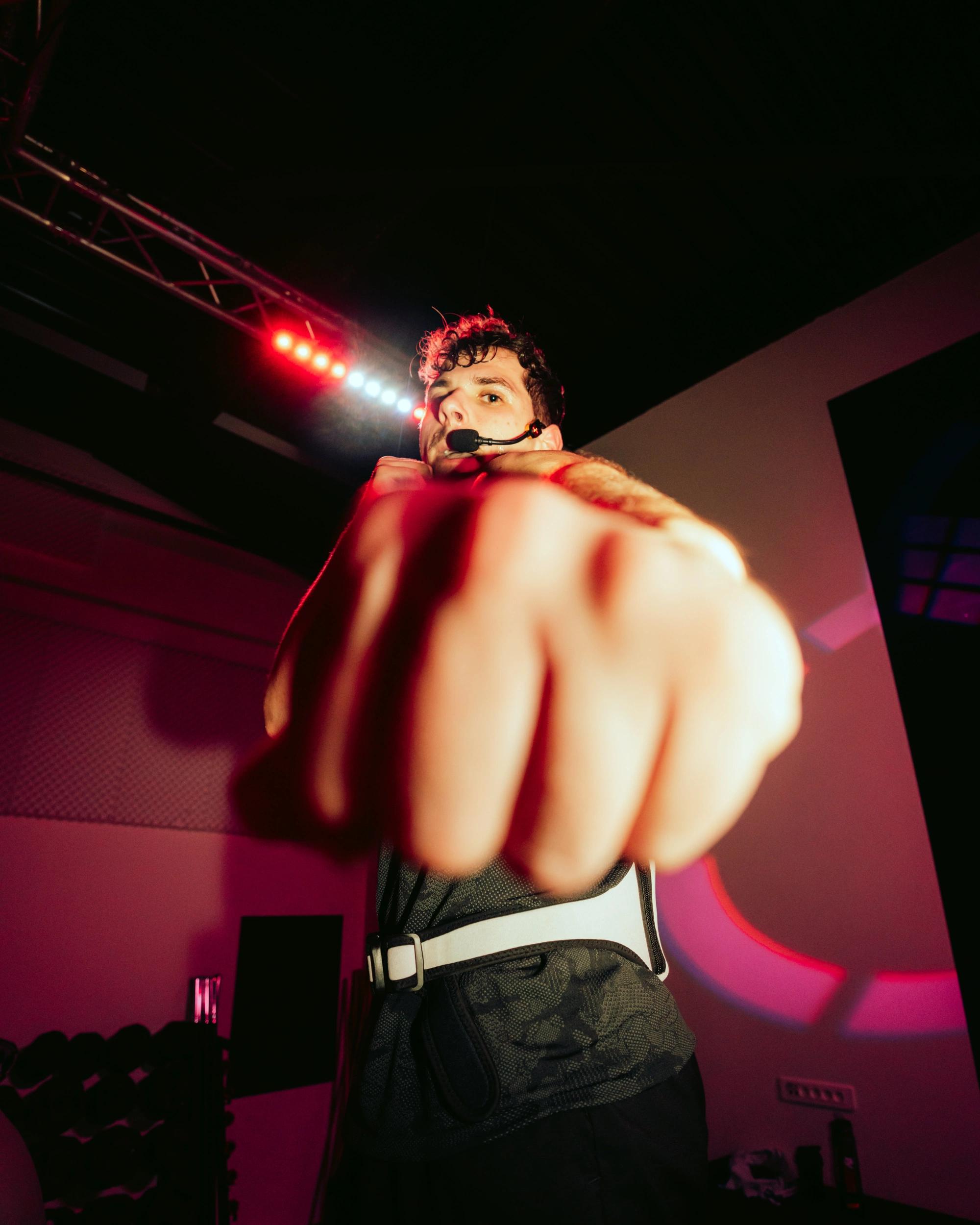 L'équipe de Webody présente un spectacle énergique avec un performeur sur scène sous les projecteurs roses