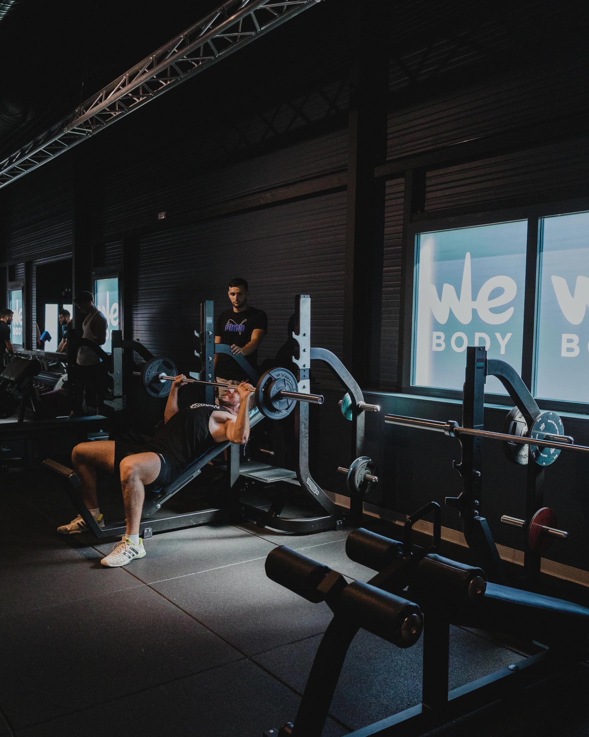 Salle de sport à Saint-Orens avec femme soulevant des poids sur banc de musculation