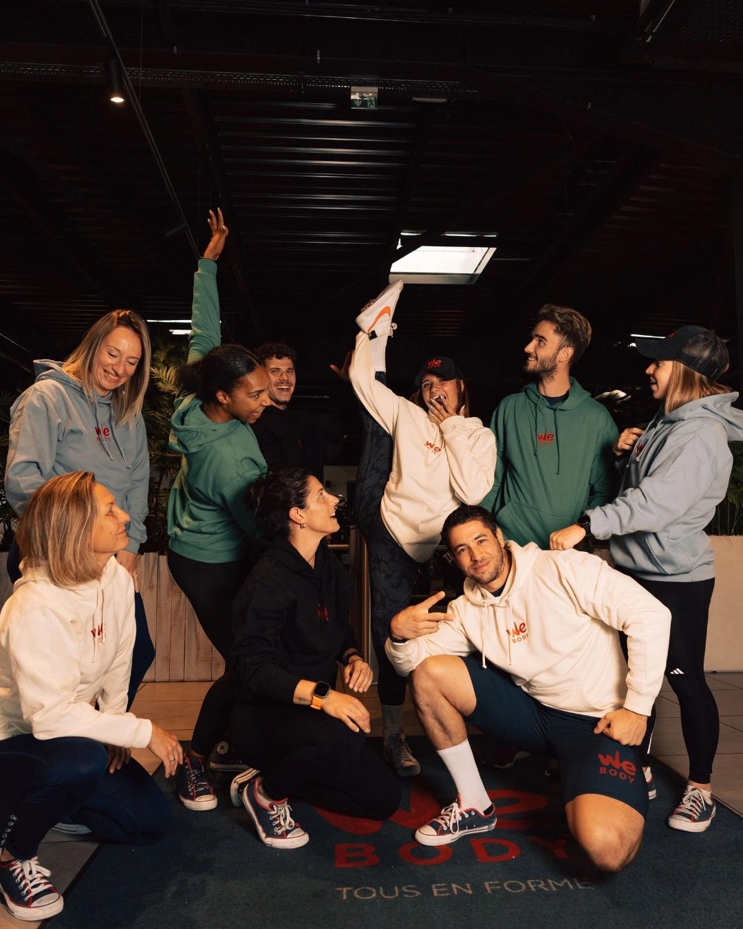 Groupe joyeux dans une salle de sport à Saint-Orens célébrant ensemble avec enthousiasme