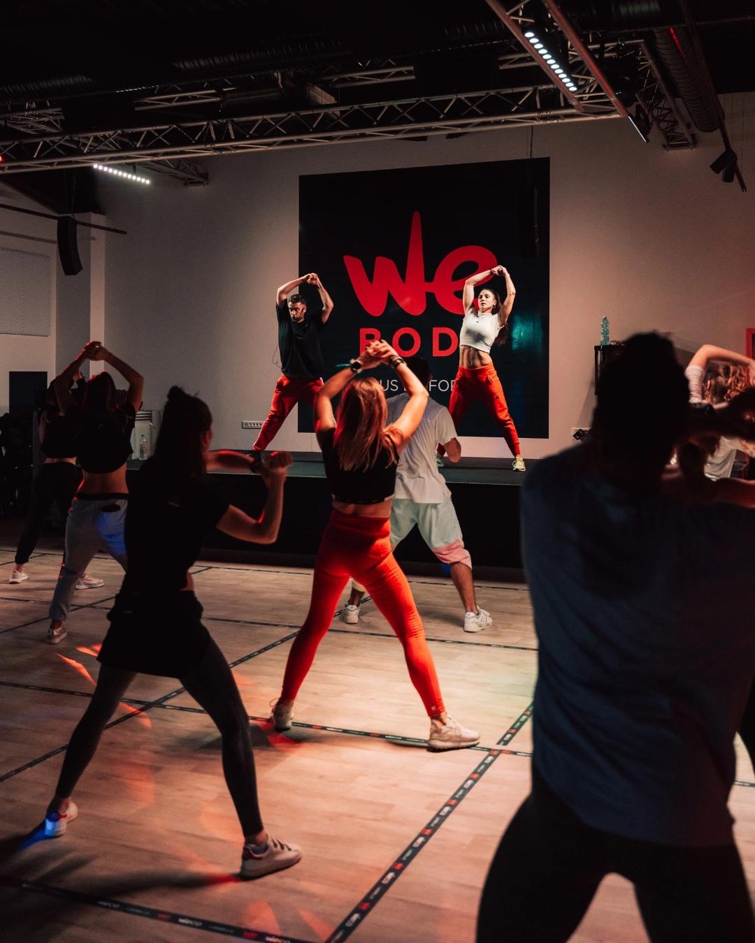Cours de fitness dynamique dans une salle de sport à Saint-Orens avec instructeurs et participants
