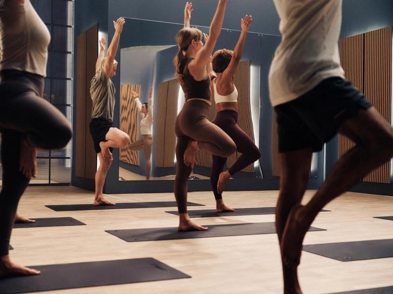 Cours de yoga collectif dans une salle de sport à Saint-Orens avec miroirs et tapis
