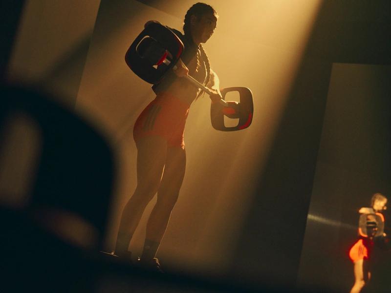 Homme musclé s'entraînant avec des kettlebells en salle de sport à Saint-Orens sous l'éclairage doré