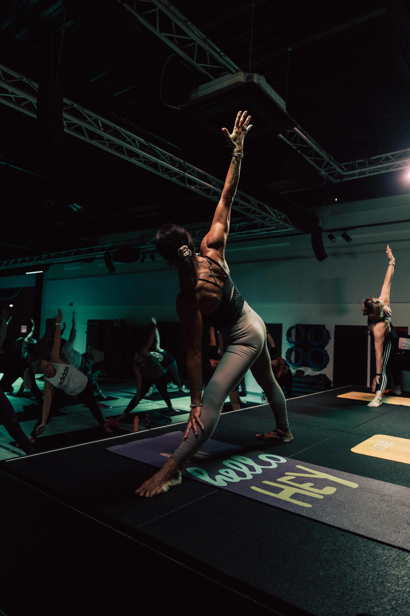 Femme pratiquant le yoga dans une salle de sport à Saint-Orens avec d'autres participants