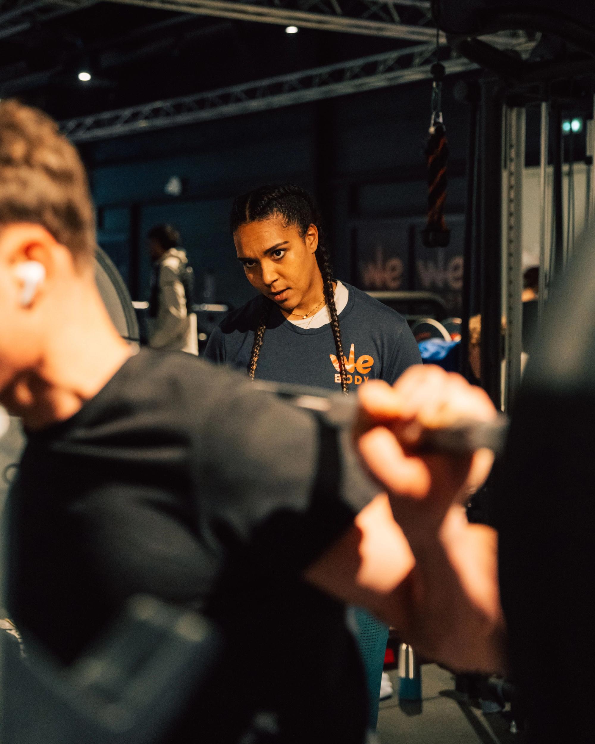 Entraineuse dans une salle de sport à Saint-Orens guidant un client lors d'une séance de fitness